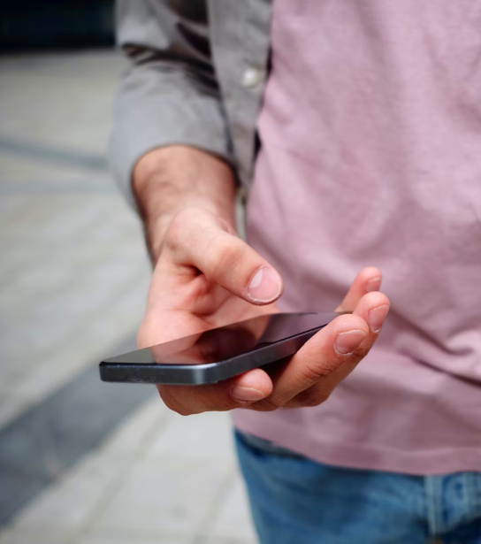 Persoon met telefoon in zijn hand.